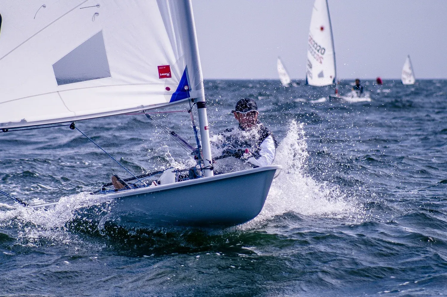 Zeiler in een zeiljol op open water, het zeil bol van de wind